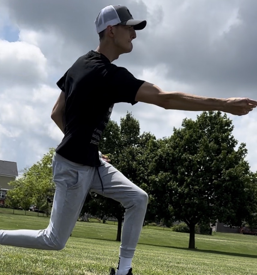 Jon throwing a disc on a sunny disc golf course